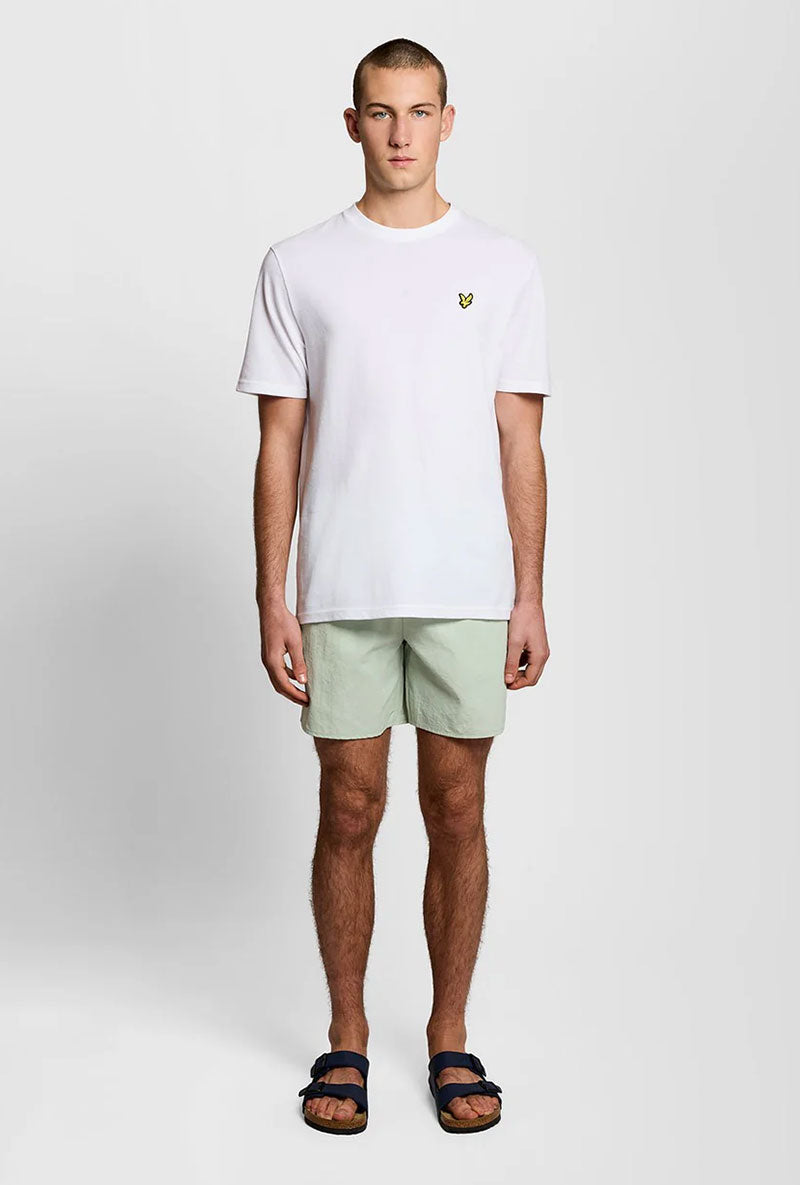 Front image of a model wearing Plain swimshorts in sage, by brand Lyle and scott