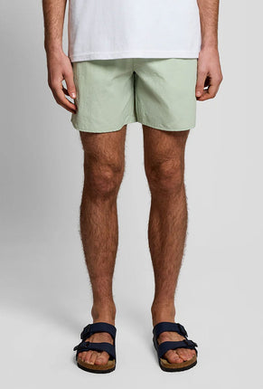 Front image of a model wearing Plain swimshorts in sage, by brand Lyle and scott