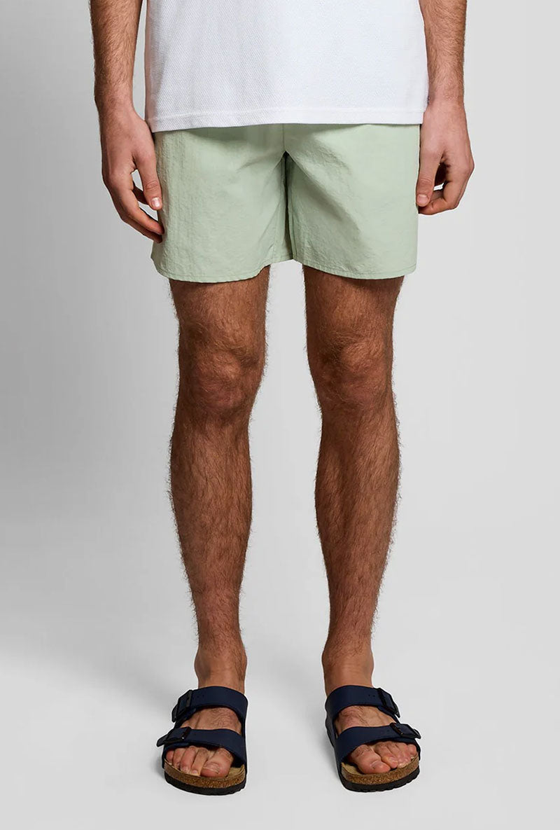 Front image of a model wearing Plain swimshorts in sage, by brand Lyle and scott