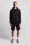 Front image of a model wearing the Sweat shorts in black, by brand Lyle and scott