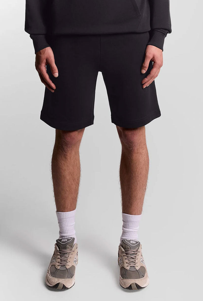 Front image of a model wearing Sweat shorts in black, by brand Lyle and scott