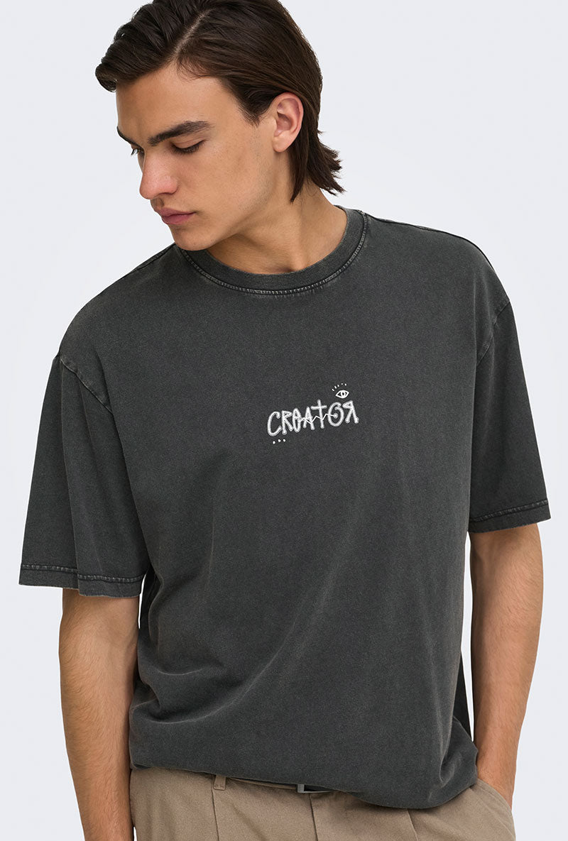 Front image of a model wearing Fred creative washed tee in black, by brand Only and sons