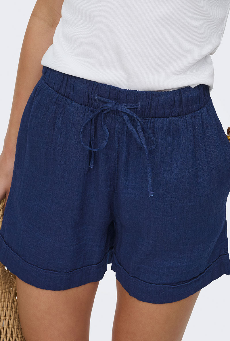 Front image of a model wearing Leoni seersucker pull up shorts in navy, by brand Only
