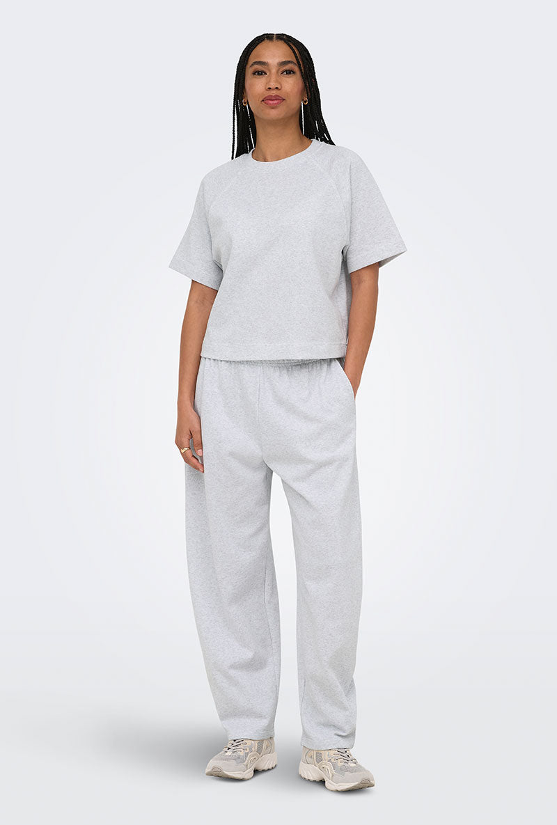 Front image of a model wearing Ofelia sweatpants in light grey, by brand Only