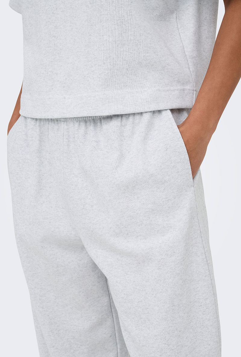 Front image of a model wearing Ofelia sweatpants in light grey, by brand Only