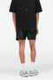 Back image of a model wearing the Micro owners club swimshorts in black, by brand Represent