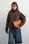 Front image of a model wearing Freya denim jacket in brown, by brand Top shop
