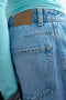 Back image of a model wearing the Joa denim barrel jort in denim, by brand Top shop