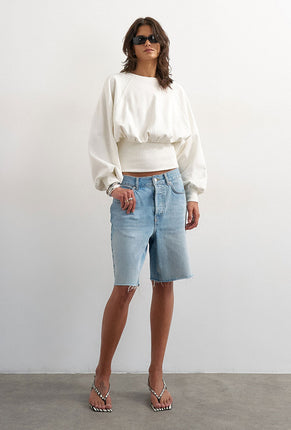 Front image of a model wearing Rega cinch waist sweatshirt in off white, by brand Top shop