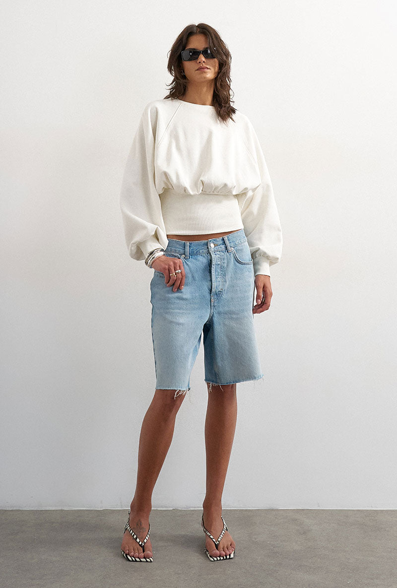 Front image of a model wearing Rega cinch waist sweatshirt in off white, by brand Top shop
