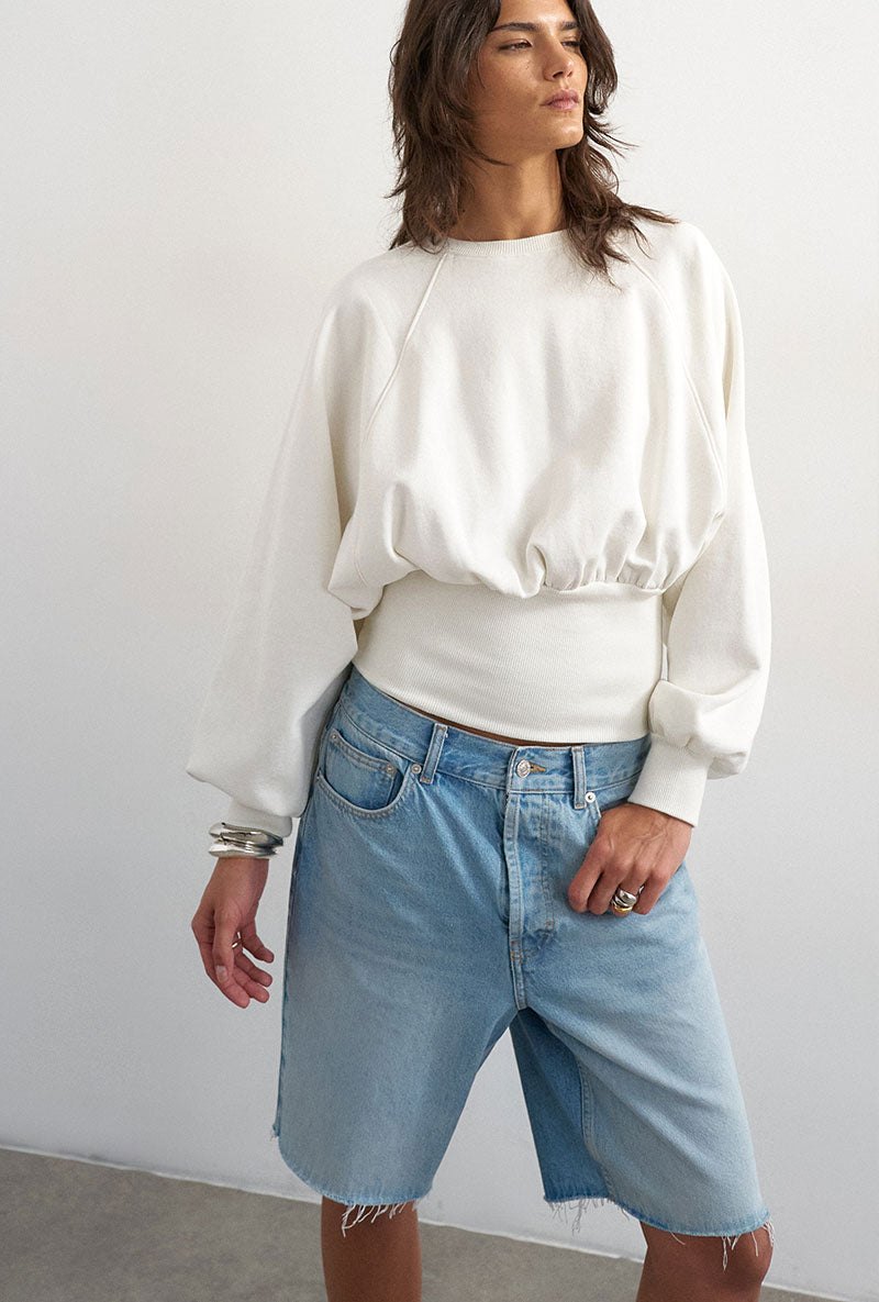 Front image of a model wearing Rega cinch waist sweatshirt in off white, by brand Top shop