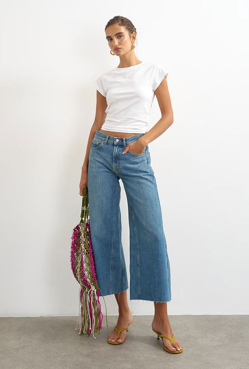 Front image of a model wearing Vera hr wide cropped jeans in denim, by brand Top shop