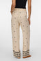 Back image of a model wearing the Kai mw pants in beige, by brand Vero moda