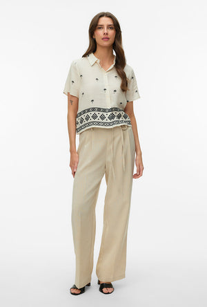 Front image of a model wearing the Kai s/s shirt in beige, by brand Vero moda