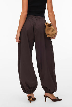 Back image of a model wearing the Lotus balloon trousers in chocolate, by brand Vero moda