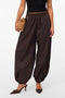 Front image of a model wearing Lotus balloon trousers in chocolate, by brand Vero moda