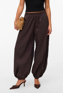 Front image of a model wearing the Lotus balloon trousers in chocolate, by brand Vero moda