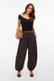 Front image of a model wearing the Lotus balloon trousers in chocolate, by brand Vero moda
