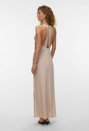 Back image of a model wearing the Reba hibisca ankle dress in beige, by brand Vero moda