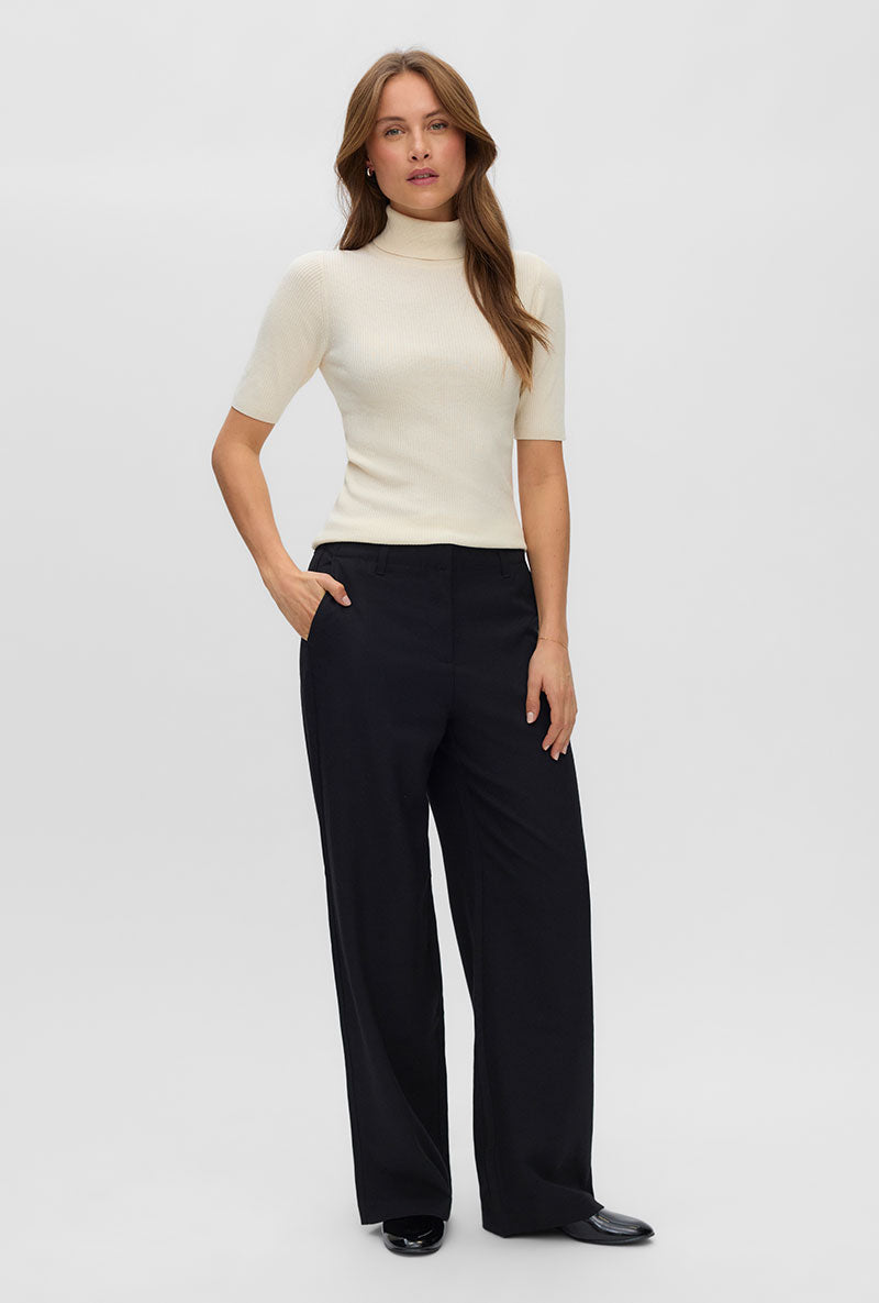 Front image of a model wearing Eyma rollneck pullover in beige, by brand Vero moda