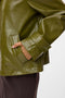 Front image of a model wearing the Dash short coated jacket in green, by brand Vero moda